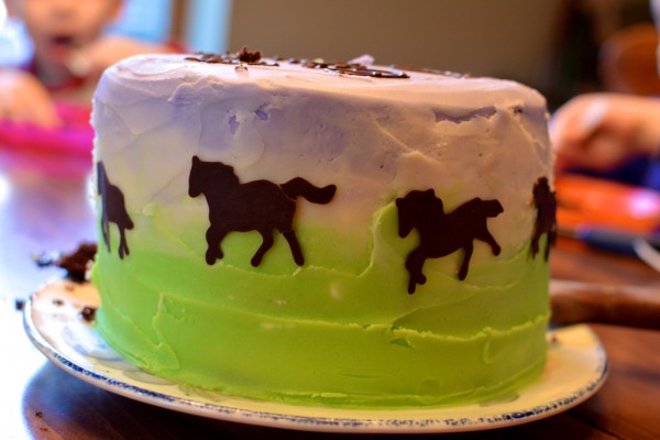 Purple and green horse cake with chocolate writing