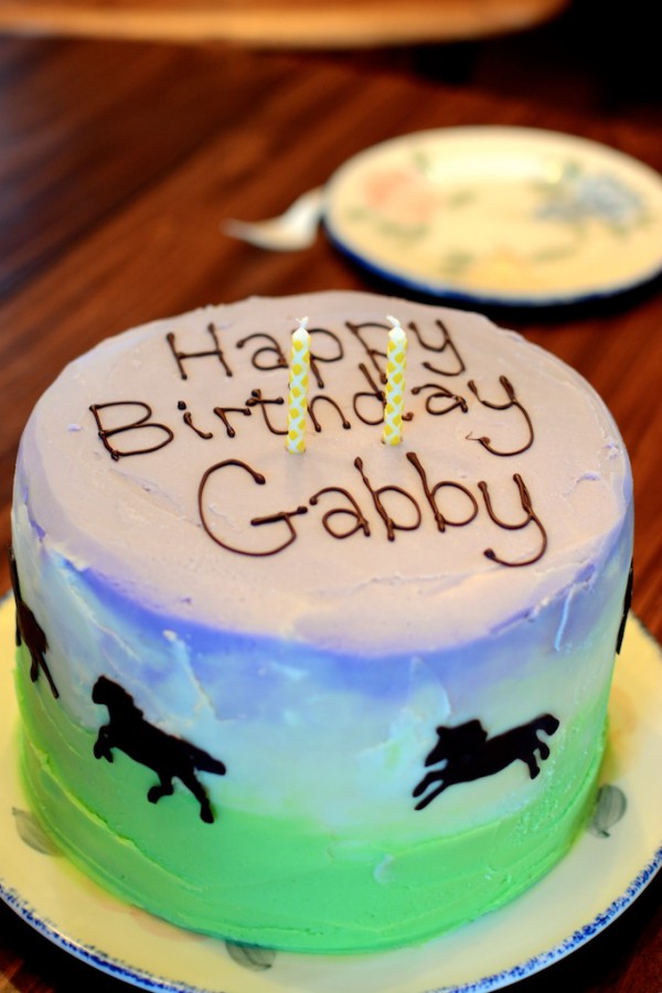 Purple and green horse cake with chocolate writing